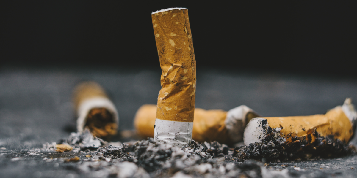 Fy for … cigaretskodder på gulvet og sort belægning giver sur smiley